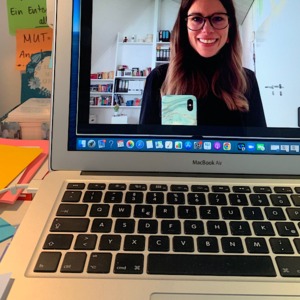 Frau mit langen Haaren und Brille macht Selfie  von sich im Laptop Bildschirm